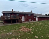 Existing red siding before seamless vinyl siding replacement